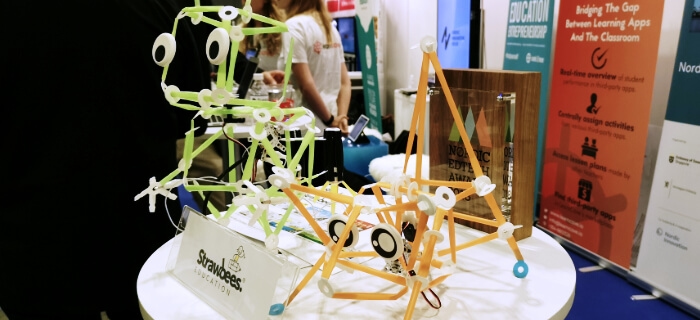 Two examples of robots built with the Strawbees construction sets, sitting behind the company logo